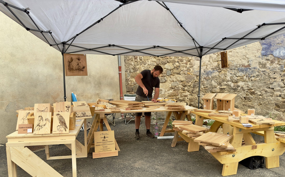 Visuel de Vincent sur son stand en foire entouré d'objets bois